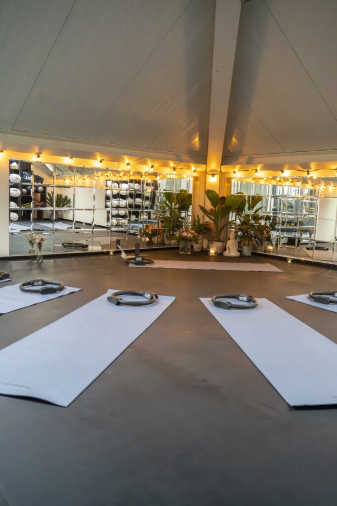 Pilates-Kursraum mit Matten und Lichterkette im Unique Gym